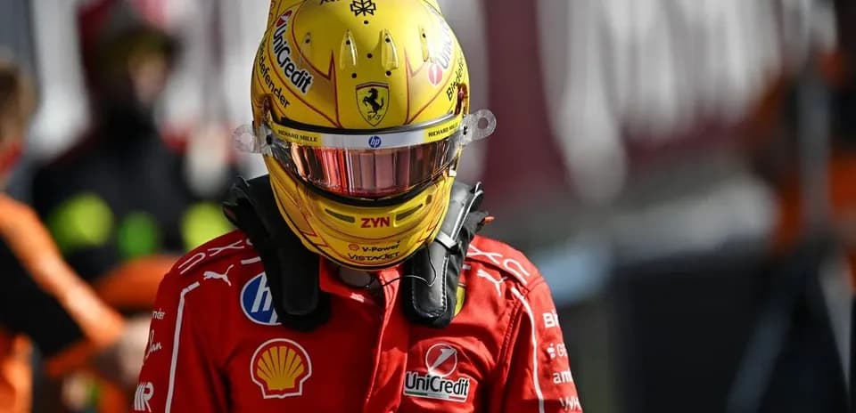 Racing driver in Ferrari suit and helmet on pit lane