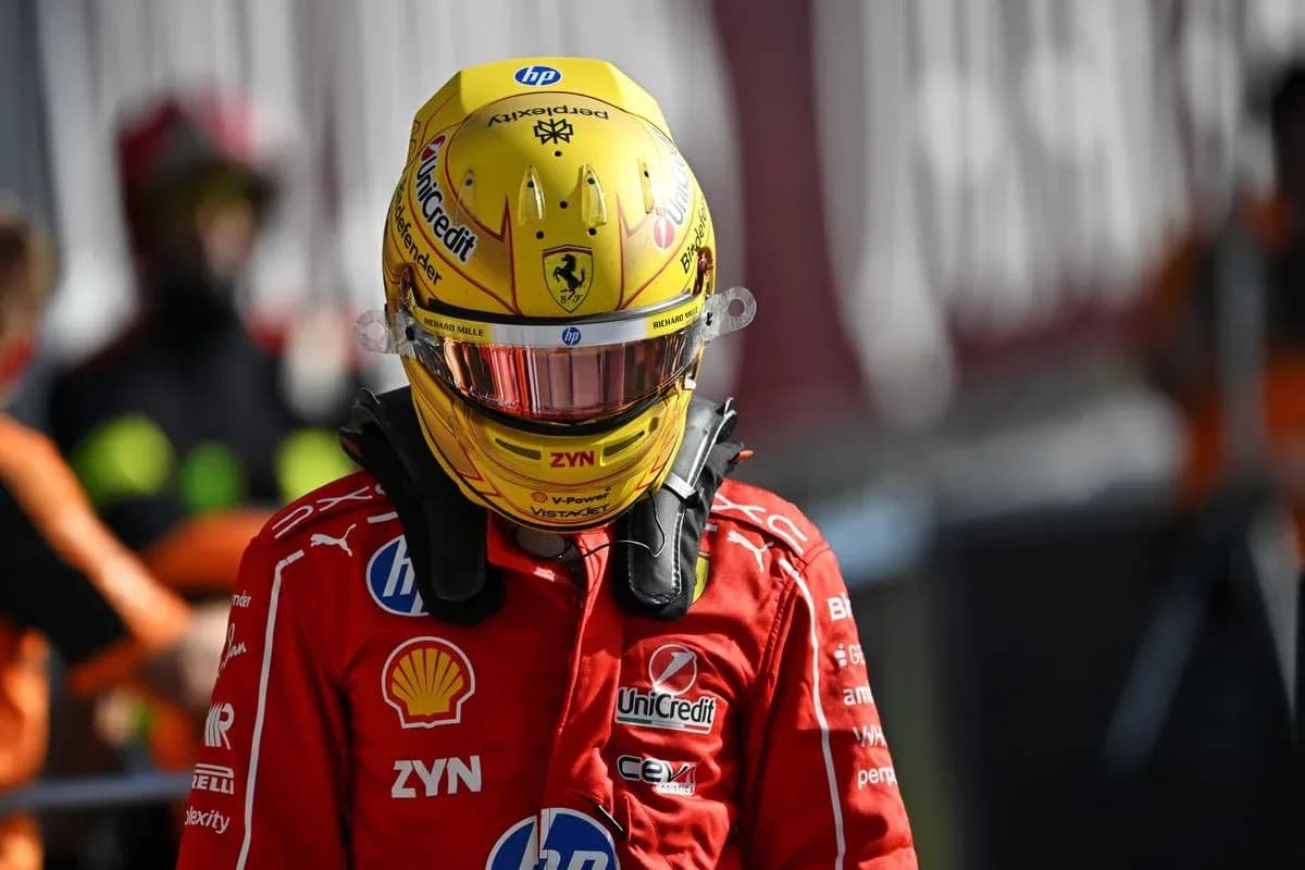 Racing driver in Ferrari suit and helmet on pit lane