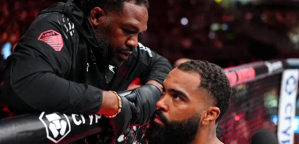 Coach advising fighter at the edge of the octagon