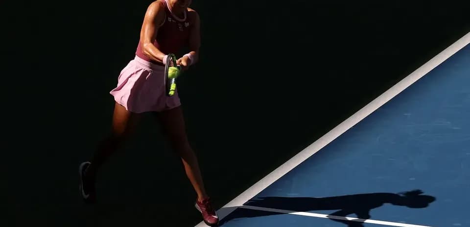 Tennis player swinging racket on court