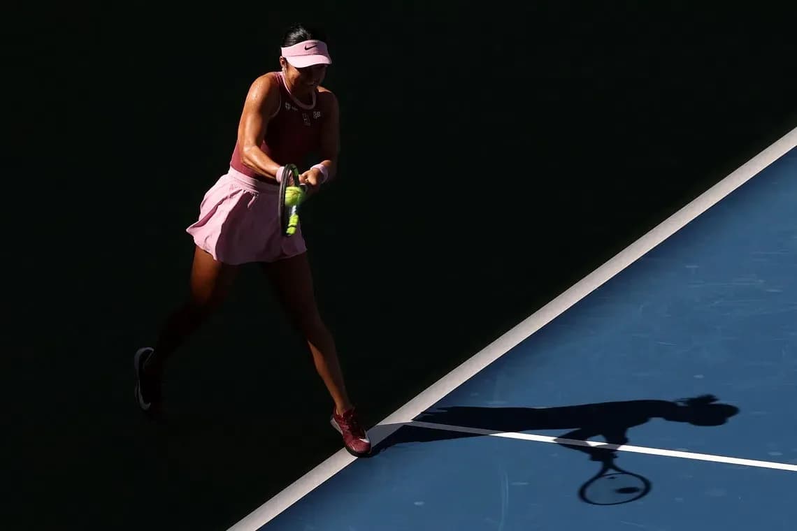 Tennis player swinging racket on court