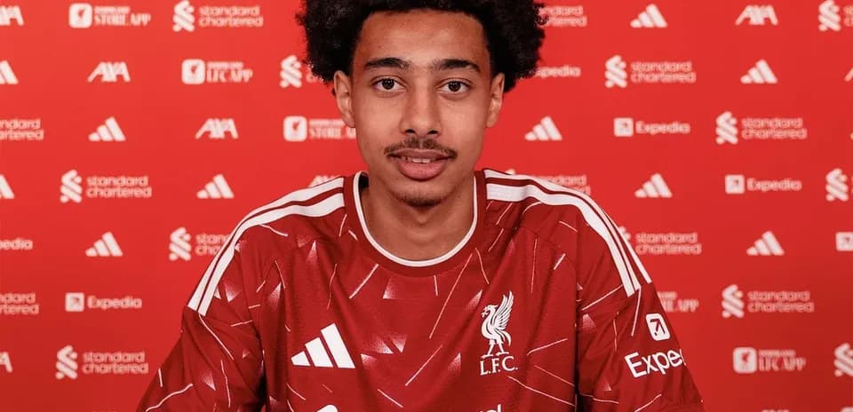 Player signing contract in Liverpool kit at press event