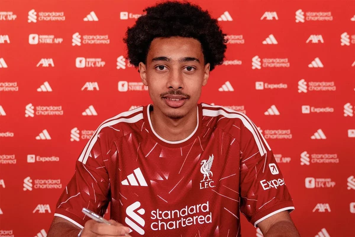 Player signing contract in Liverpool kit at press event