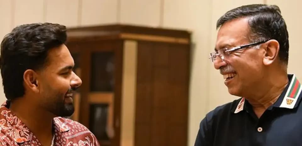Two men smiling and talking indoors