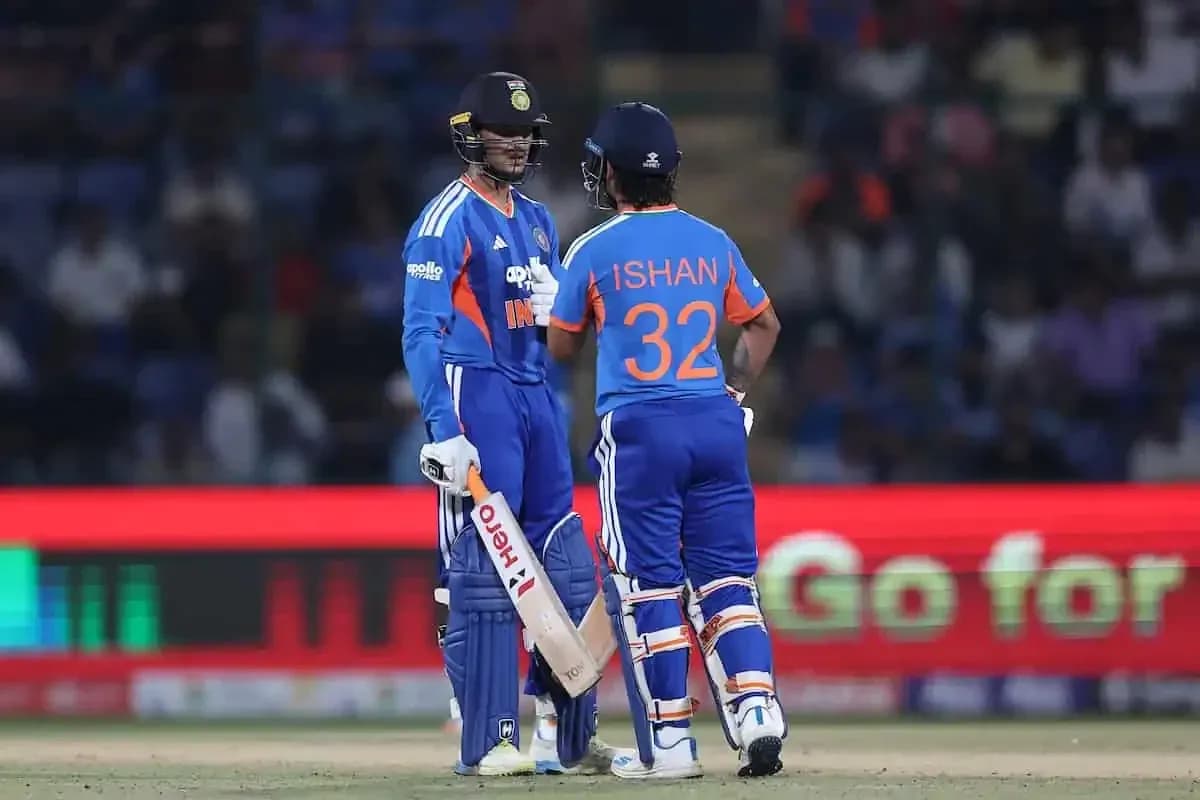 Two cricketers discussing strategy on the field