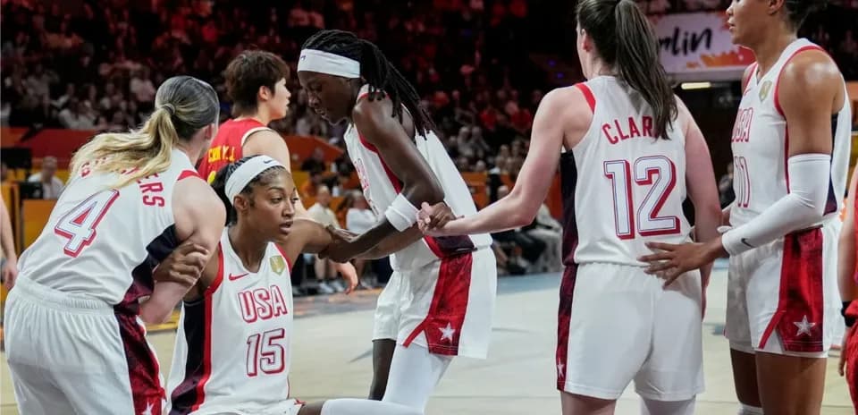 USA basketball players supporting teammate on court