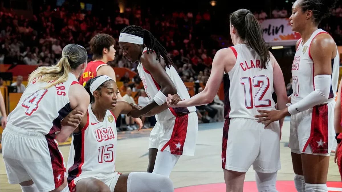 USA basketball players supporting teammate on court