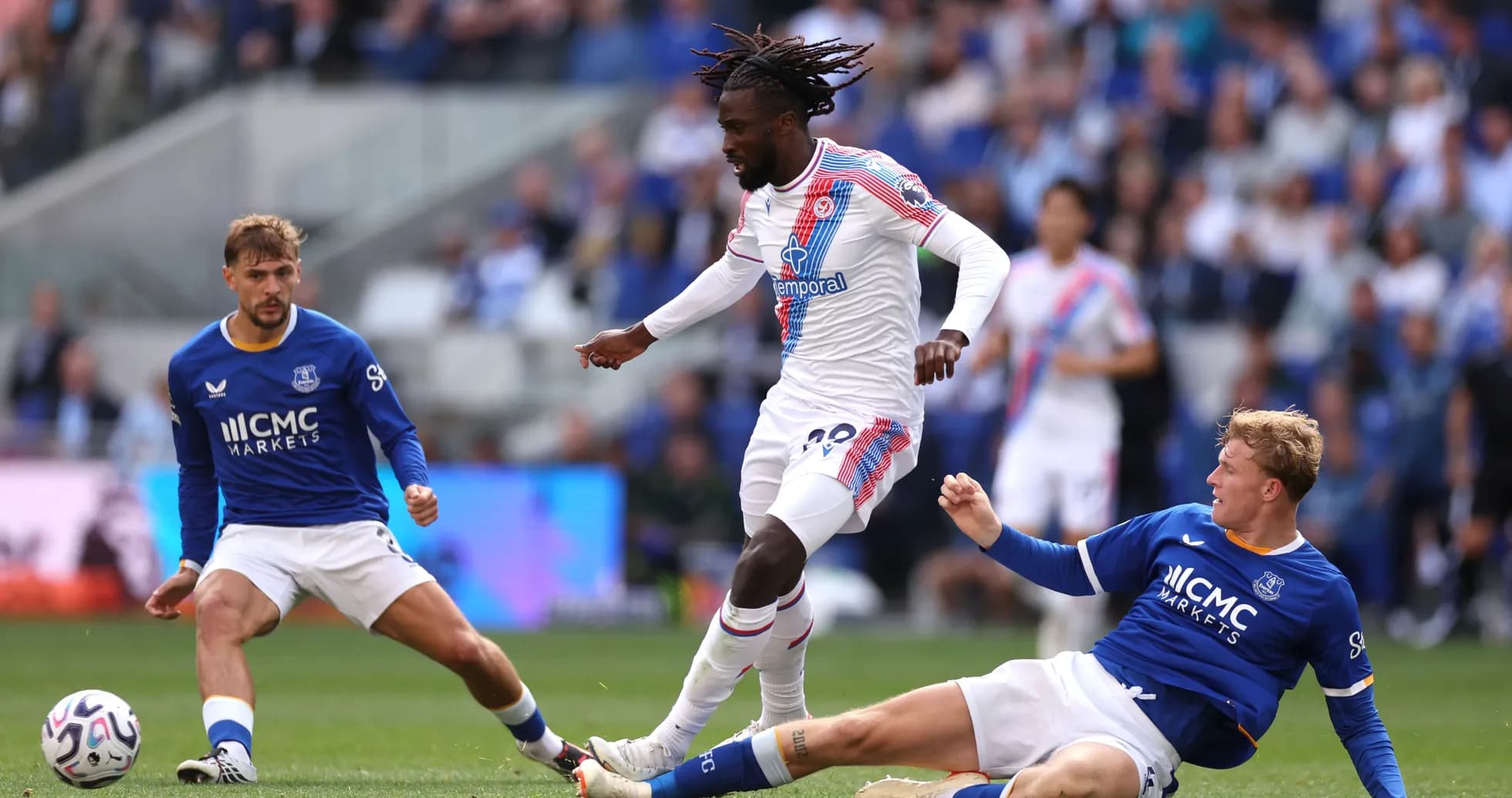 Player in white dribbling past two defenders in blue