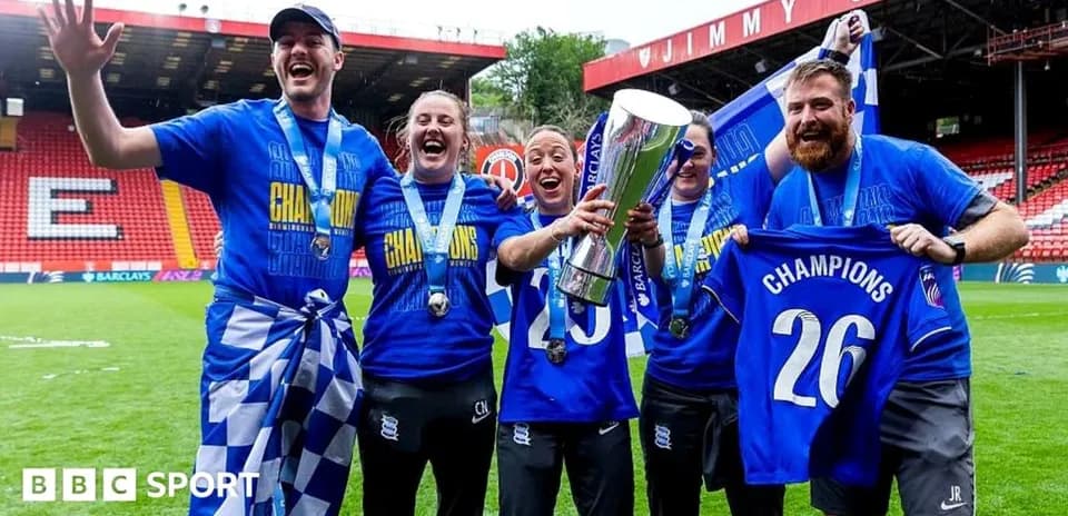 Team celebrating with trophy and champion shirts