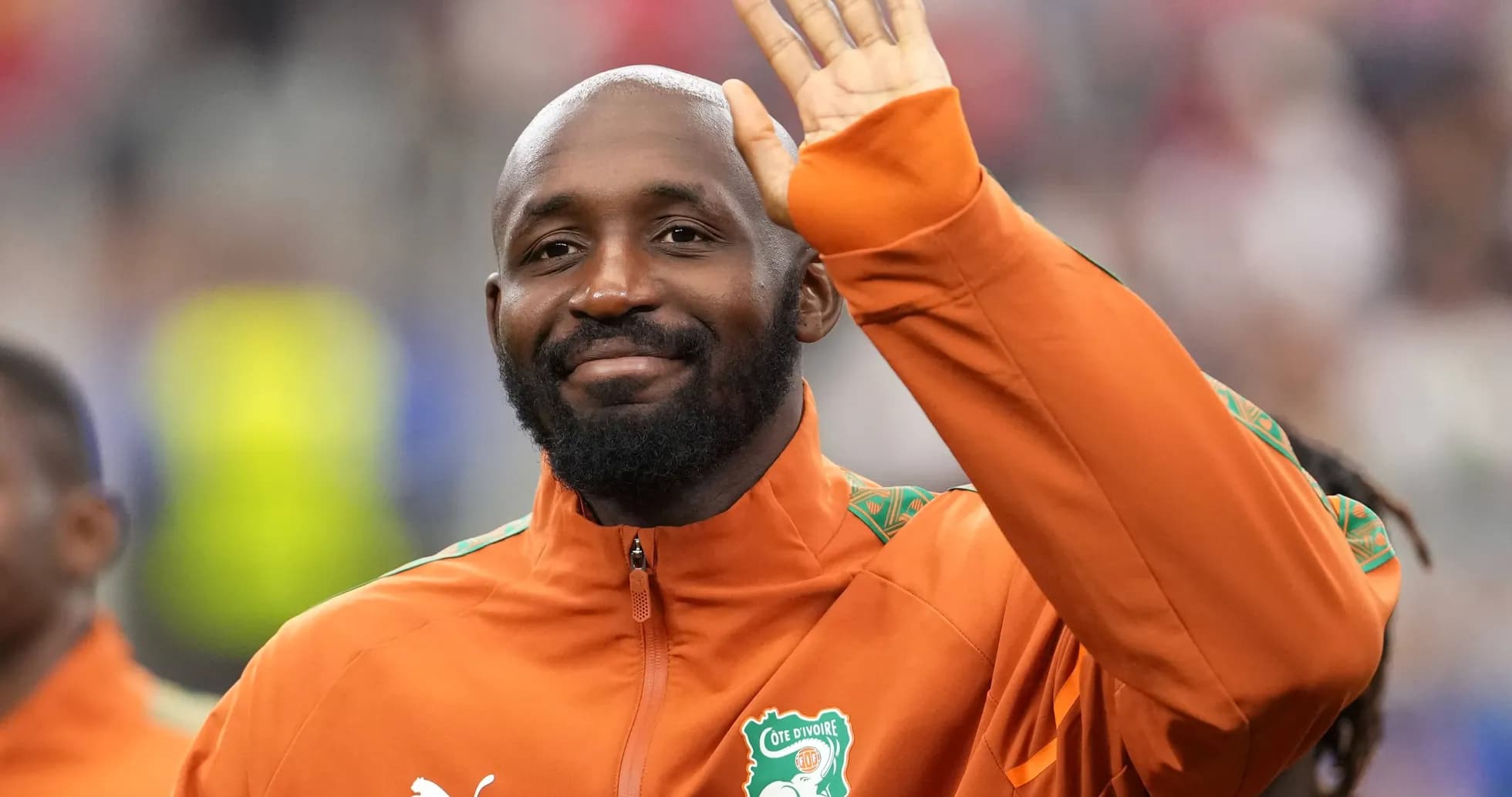 Player waving while wearing Cote d'Ivoire training jacket