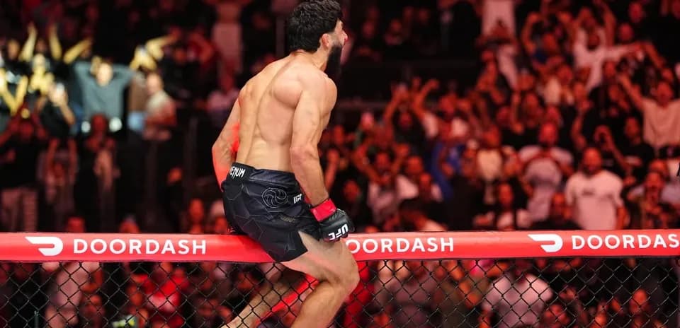 Fighter celebrating victory on the cage fence