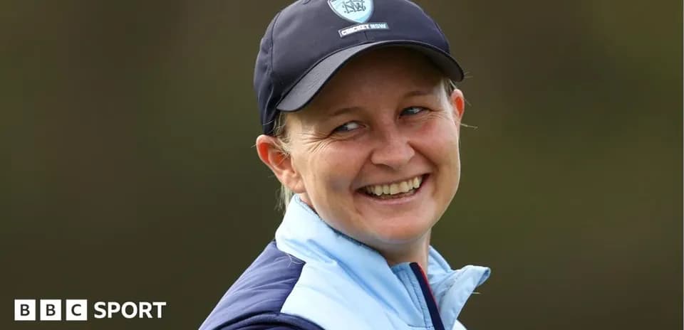 Cricket coach smiling during outdoor event