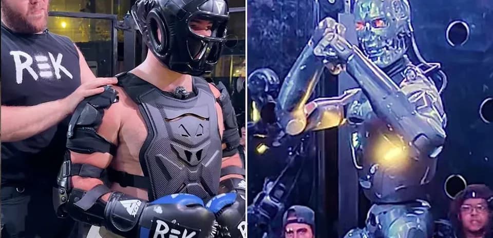 Man in protective gear stands beside a robot