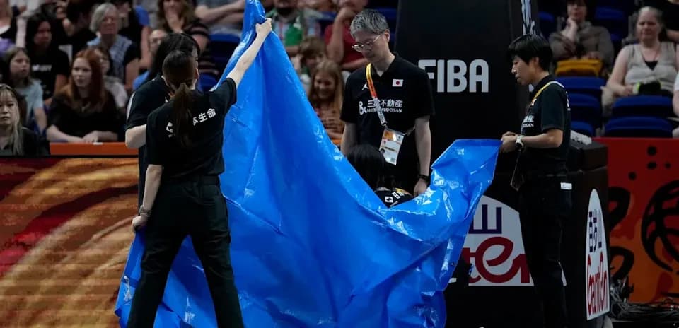 Crew covering the court with a blue tarp