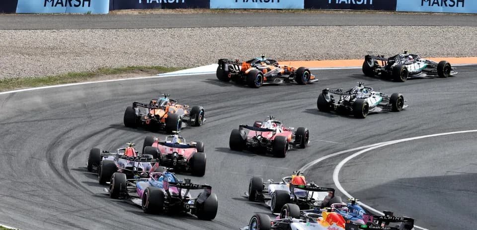 Multiple Formula 1 cars racing on a curved track