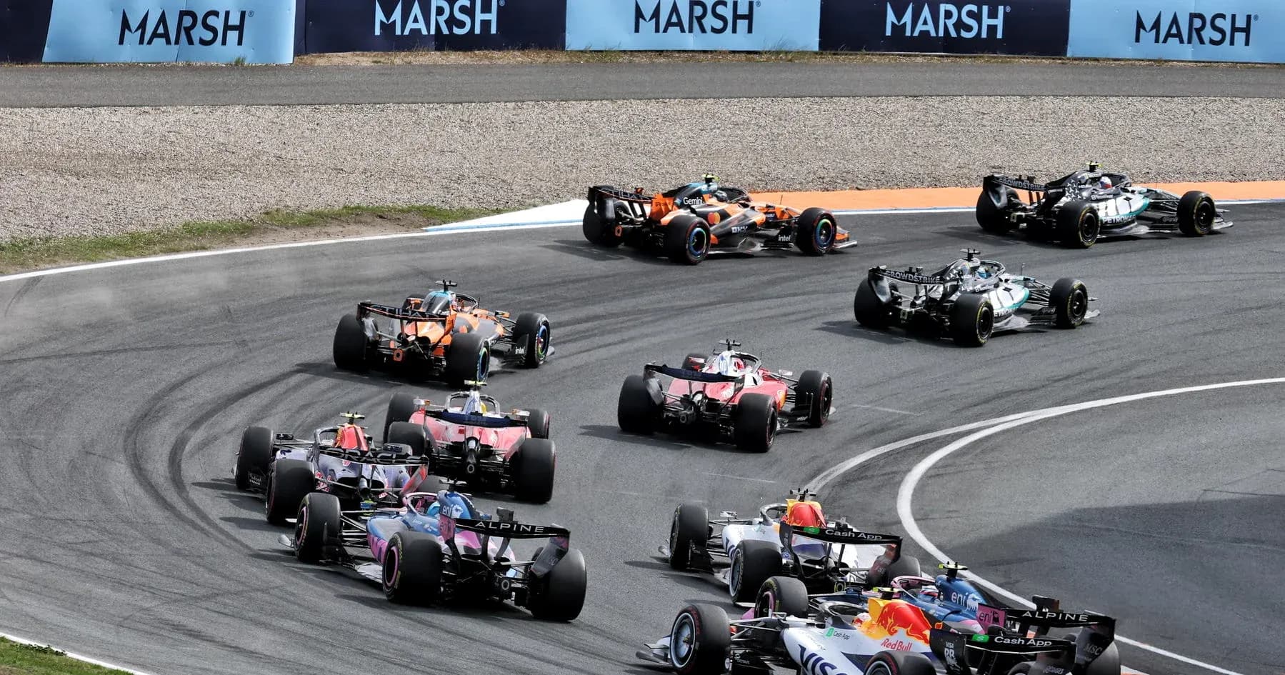 Multiple Formula 1 cars racing on a curved track