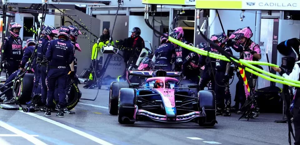Alpine F1 car in pit stop with team members