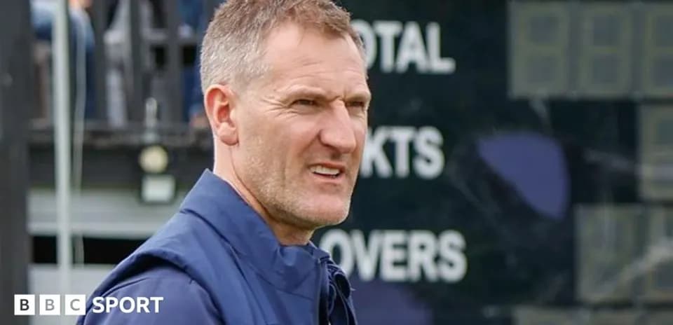 Coach observing scoreboard during cricket match