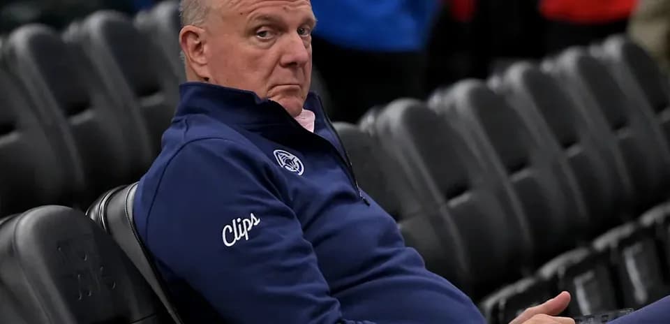 Man seated in arena wearing Clippers attire