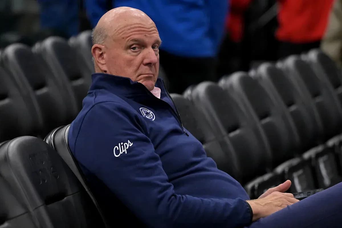 Man seated in arena wearing Clippers attire