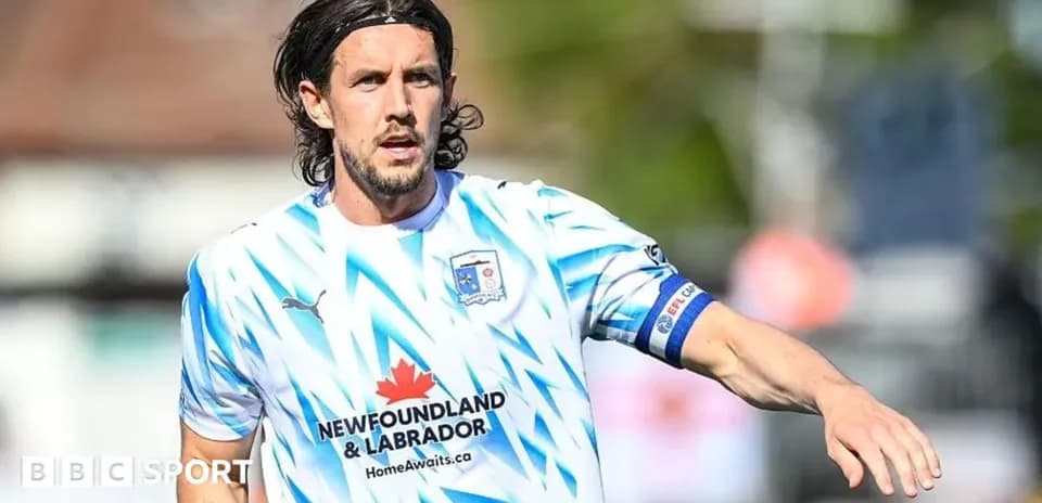 Player in blue and white kit on field