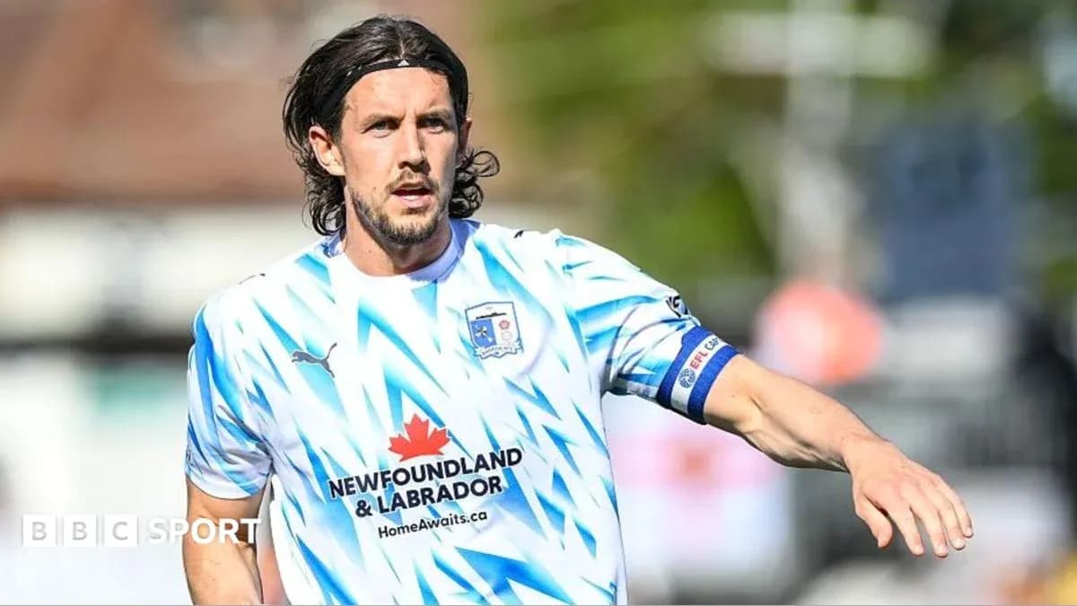 Player in blue and white kit on field