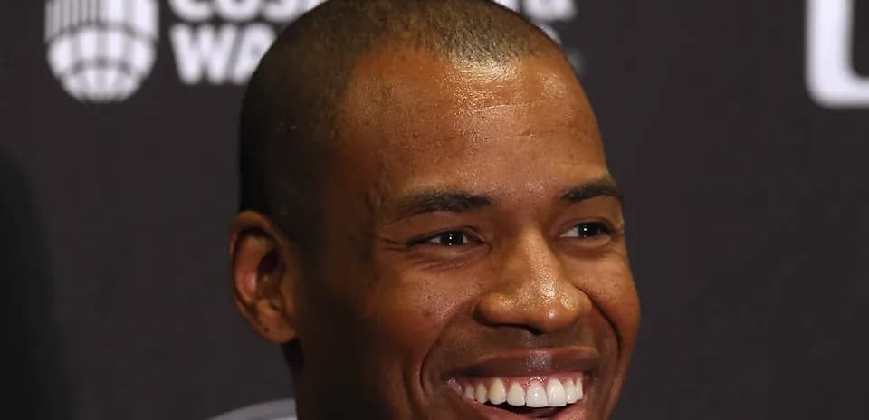 Person smiling at a press conference backdrop