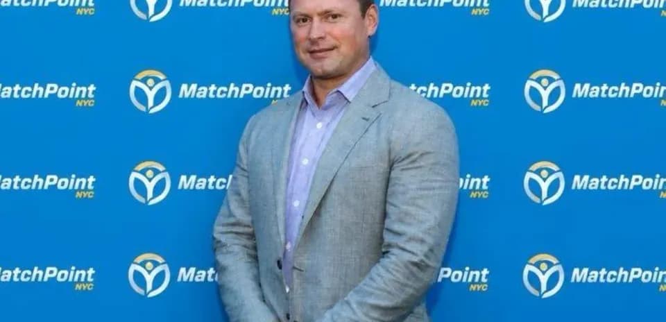 Individual posing in front of MatchPoint NYC backdrop