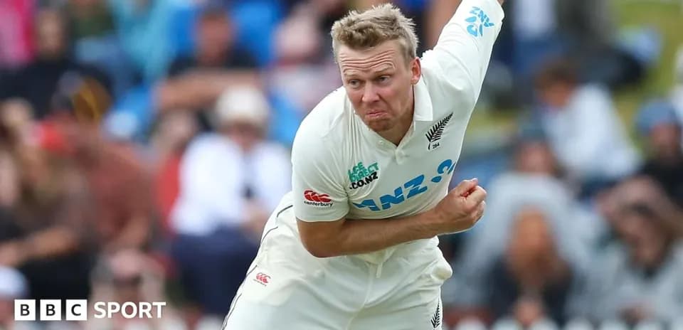 Cricketer bowling during a match in white kit