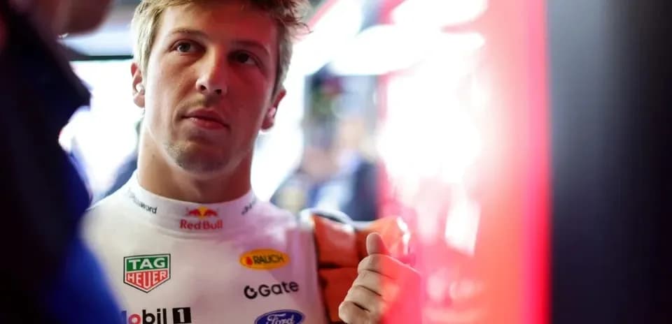 Driver in racing suit preparing in pit area