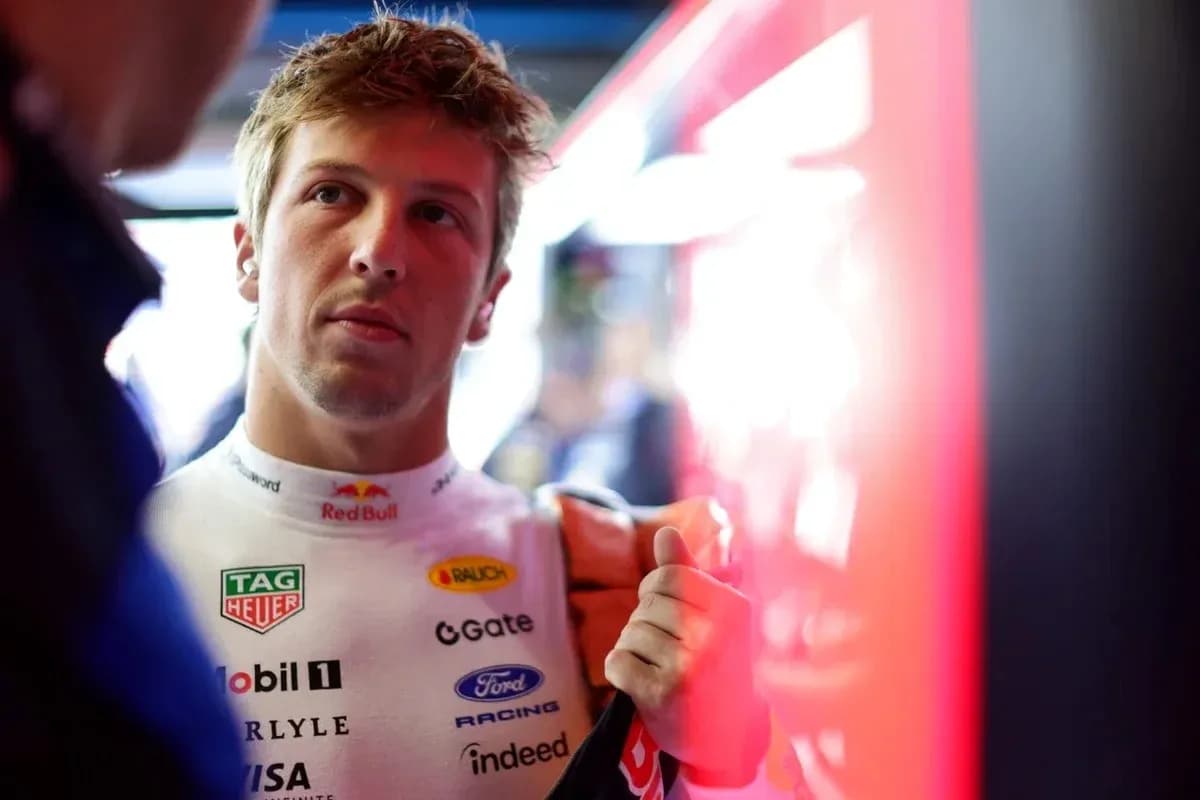 Driver in racing suit preparing in pit area