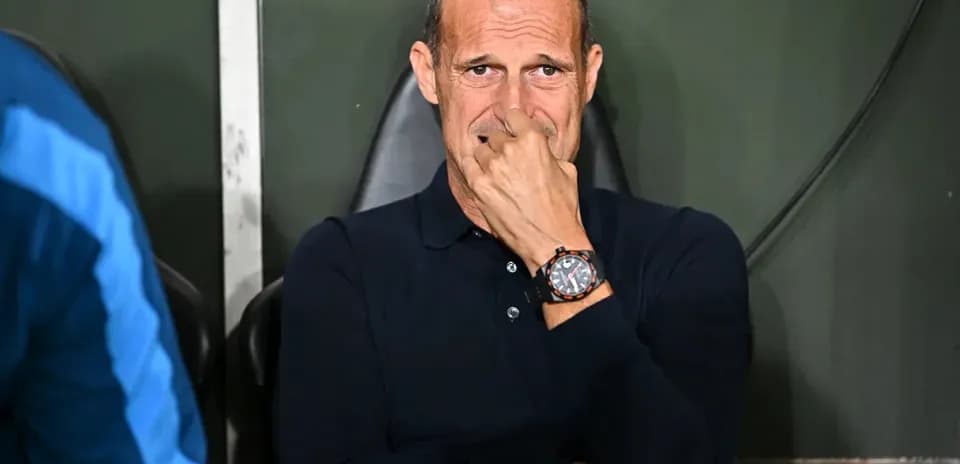 Coach seated on bench during match, deep in thought