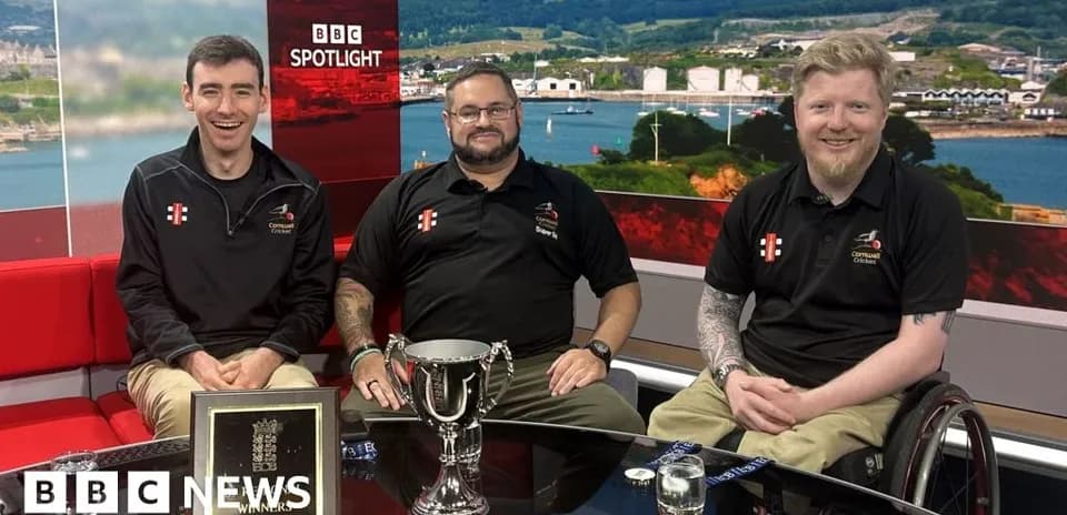 Three men celebrating with trophy on studio set
