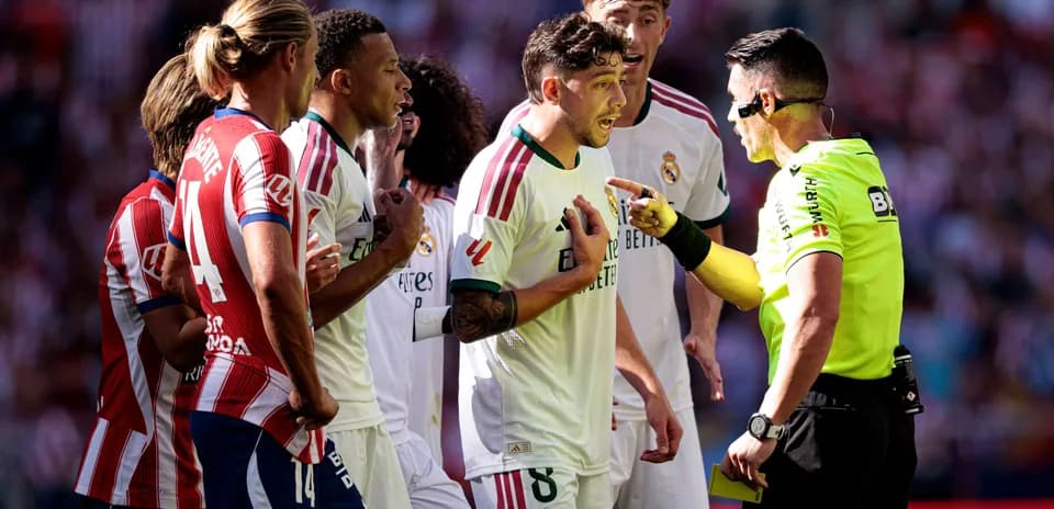 Players surrounding referee during heated match discussion