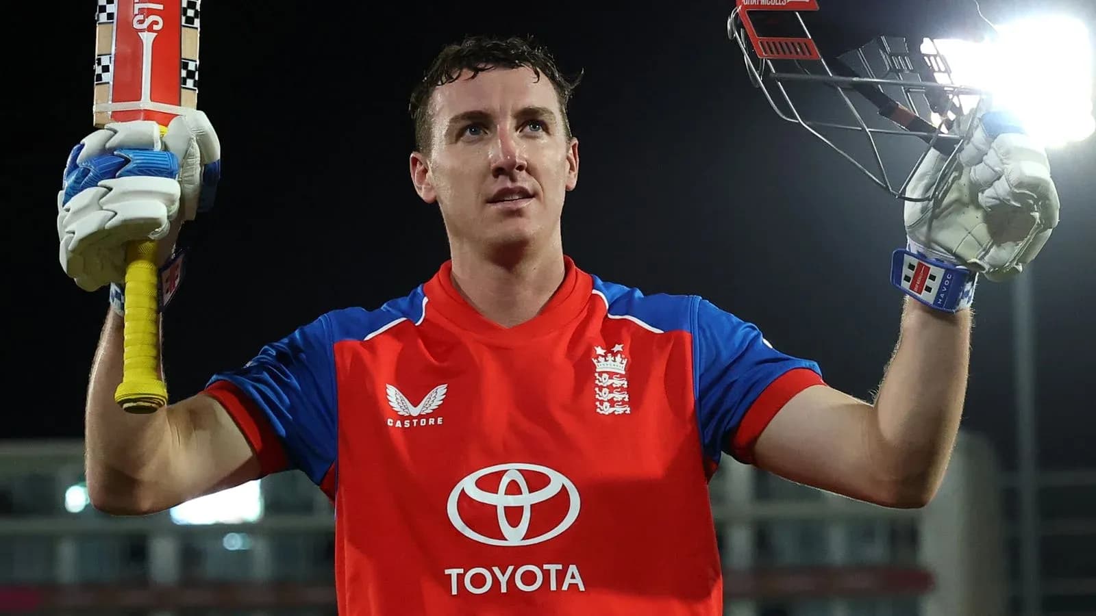 Batsman celebrating with raised bat after scoring