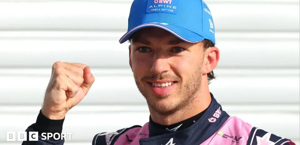 Driver celebrating with fist raised in team uniform
