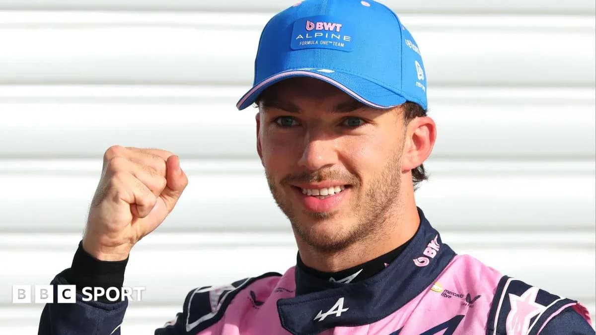 Driver celebrating with fist raised in team uniform