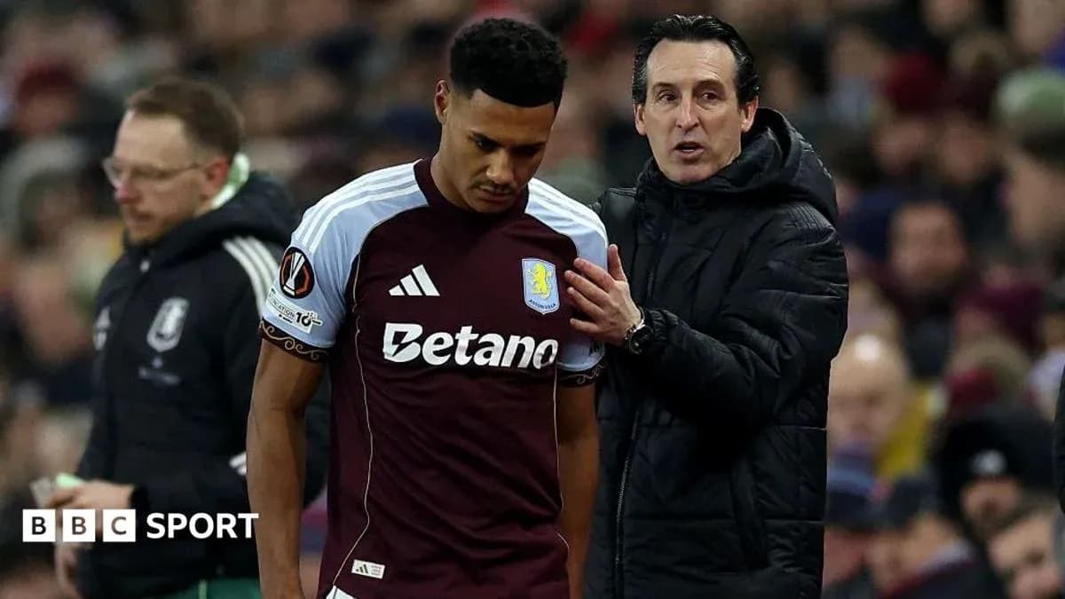 Aston Villa player speaking with manager during match