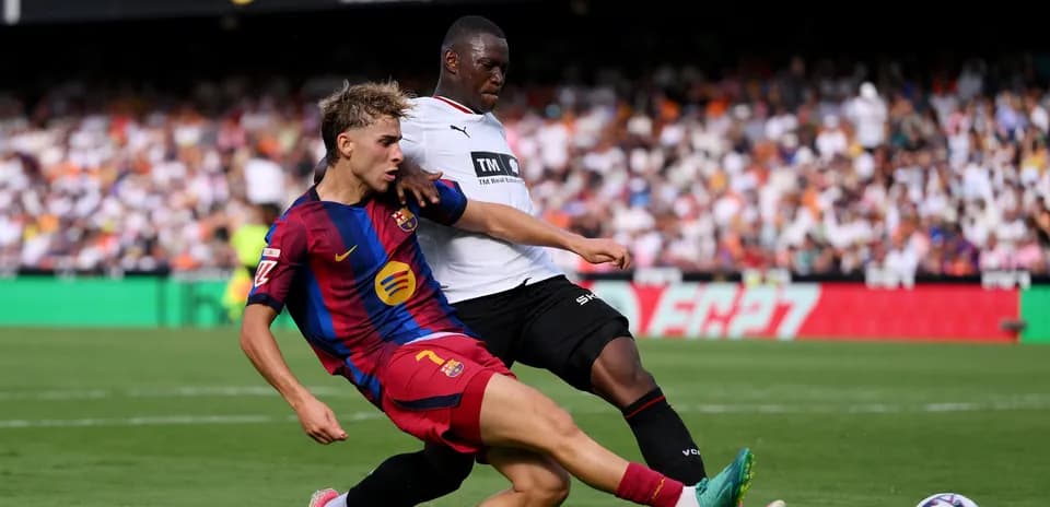 Barcelona player challenged by opposing defender during match