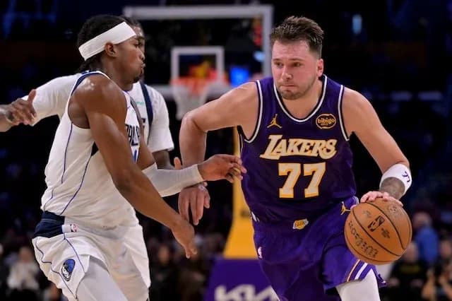 Player dribbling basketball while being defended