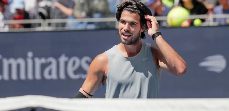 Tennis player adjusting hair during match on court