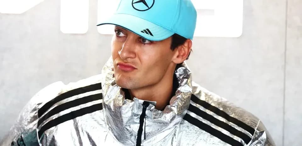 Driver in silver jacket and blue cap at event