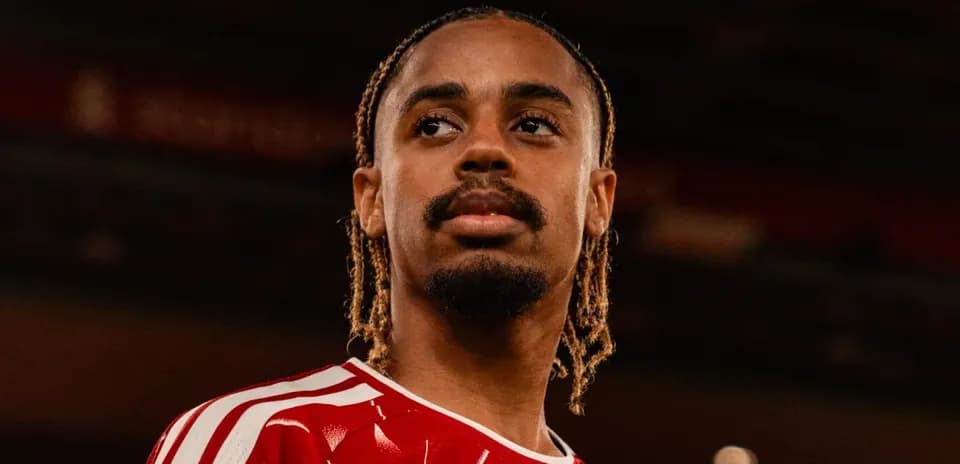 Player posing in red jersey with braided hair