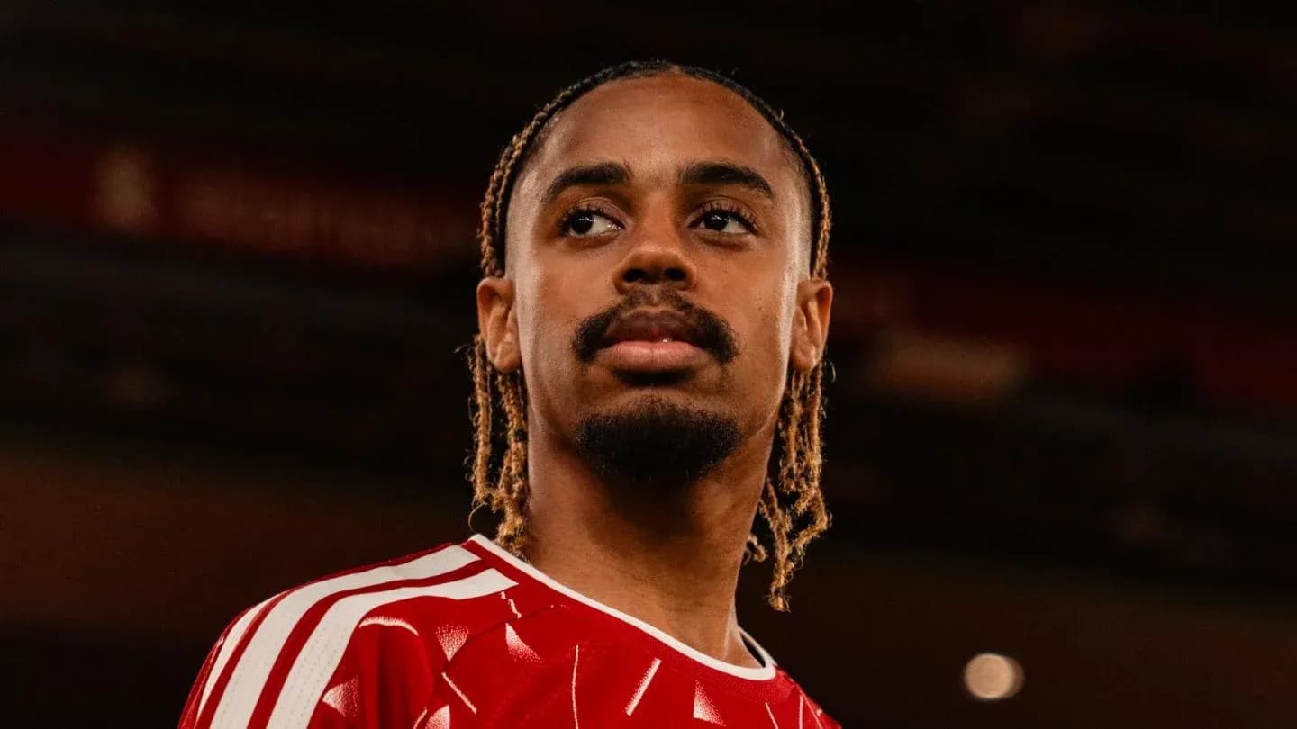 Player posing in red jersey with braided hair