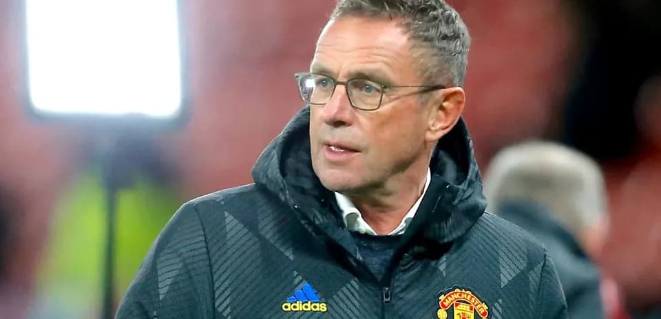Coach wearing Manchester United jacket on sidelines