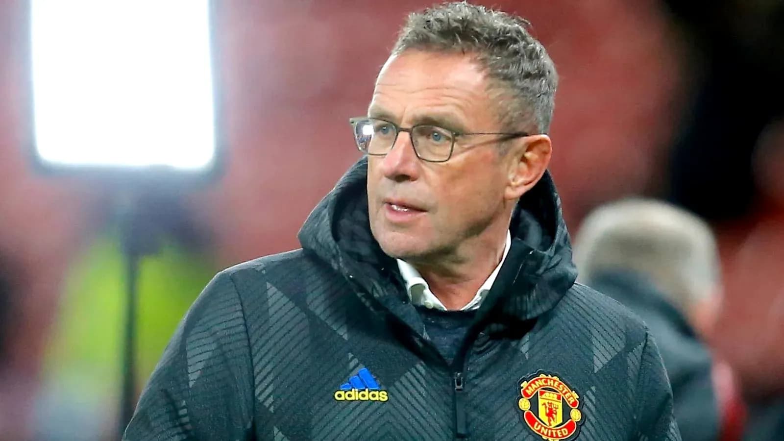 Coach wearing Manchester United jacket on sidelines