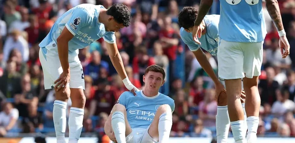 Manchester City players attend to injured teammate