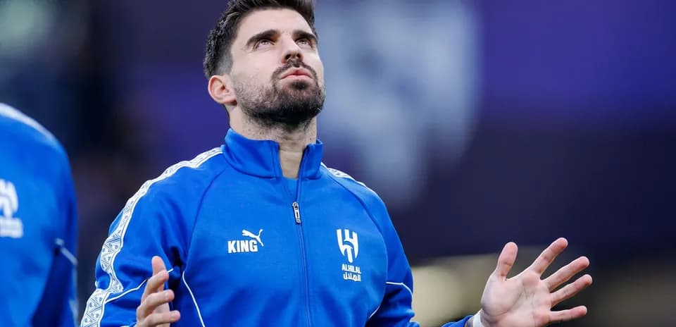 Player in blue jacket looking up before match