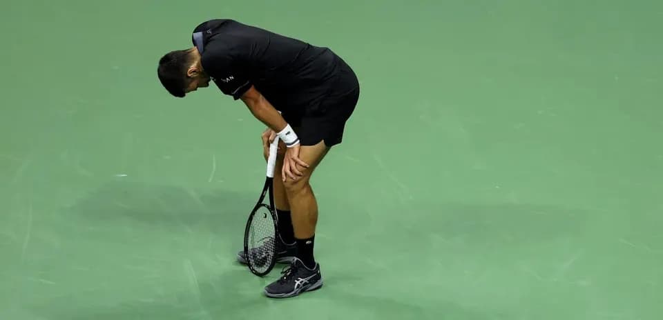 Player bending over on tennis court after match