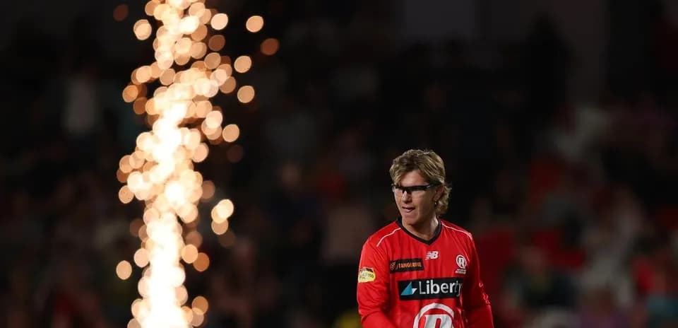Player in red uniform walking past fireworks display